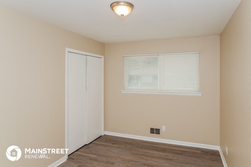 the upstairs bedroom with a door to the closet and a window