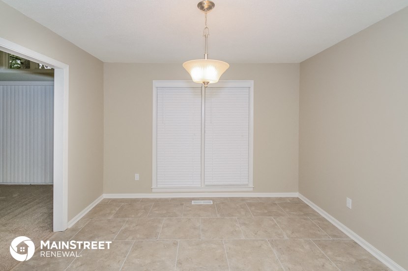the spacious dining room has a large window and tile flooring