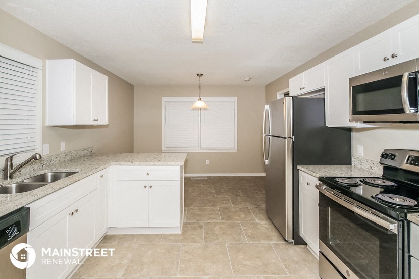 a kitchen with stainless steel appliances and white cabinets