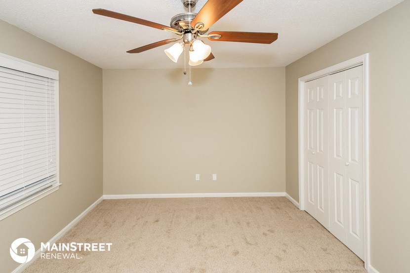 the master bedroom has a ceiling fan and a closet