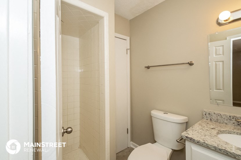a bathroom with a toilet and a shower and a sink