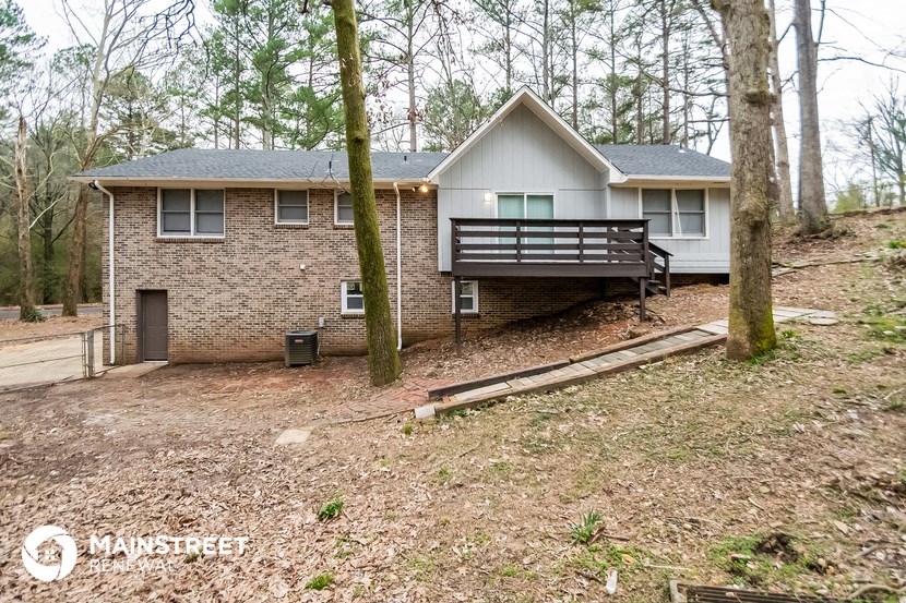 a small house in the woods with a deck