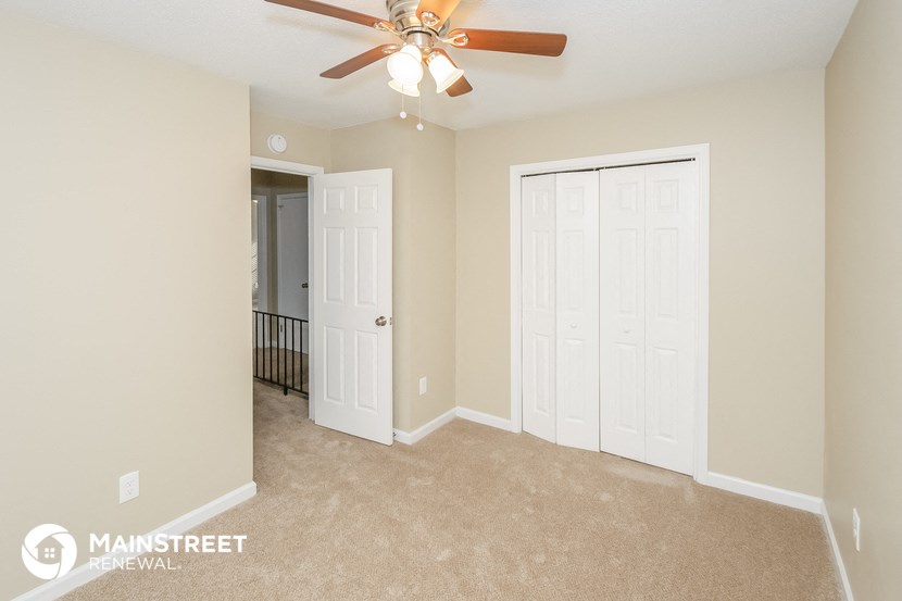 a bedroom with two closets and a ceiling fan