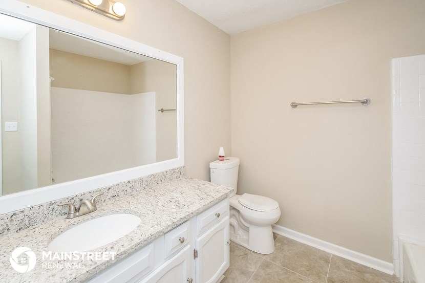 a bathroom with a large mirror and a toilet and a sink