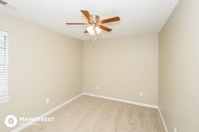 a bedroom with carpet and a ceiling fan