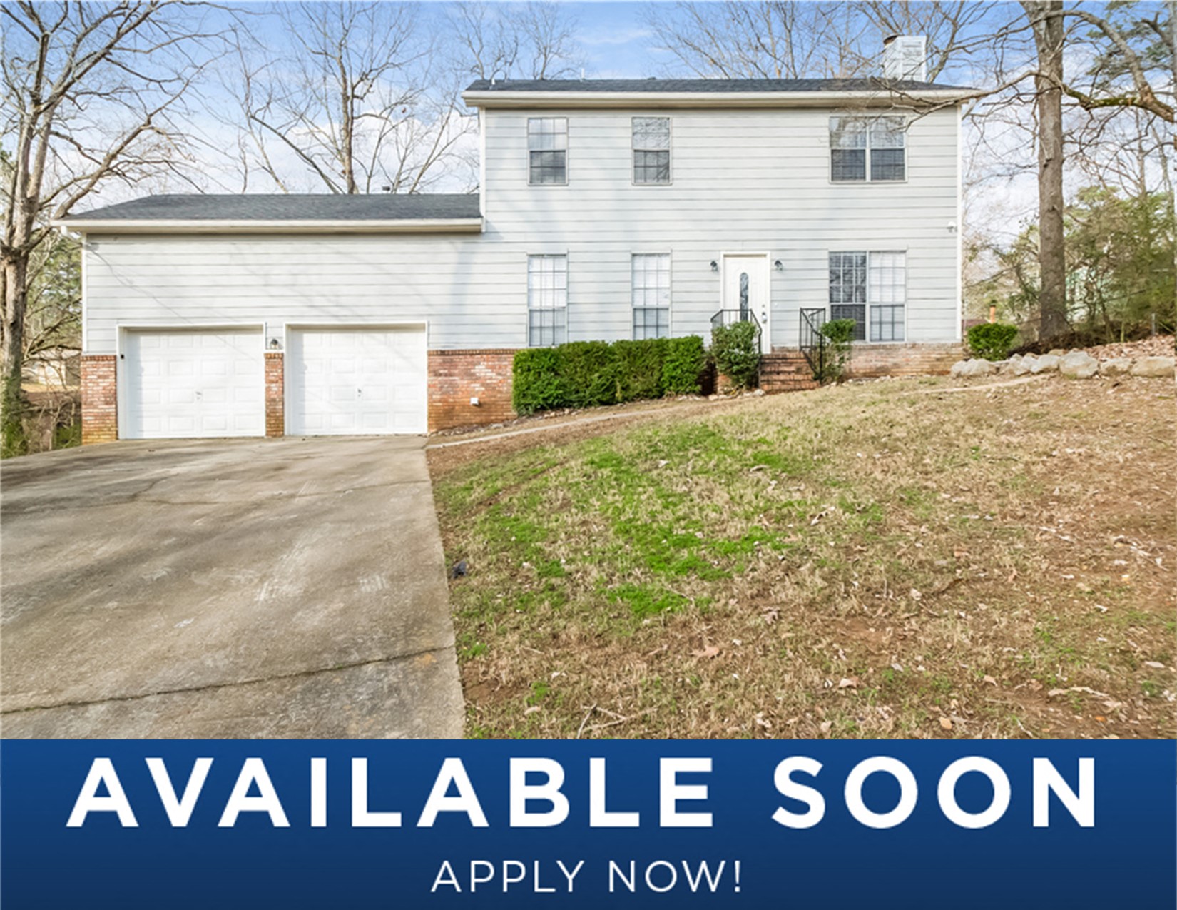 a white house with two garage doors and a lawn