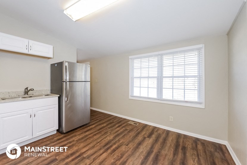 the kitchen of our studio apartment atrium with stainless steel refrigerator and white cabinets