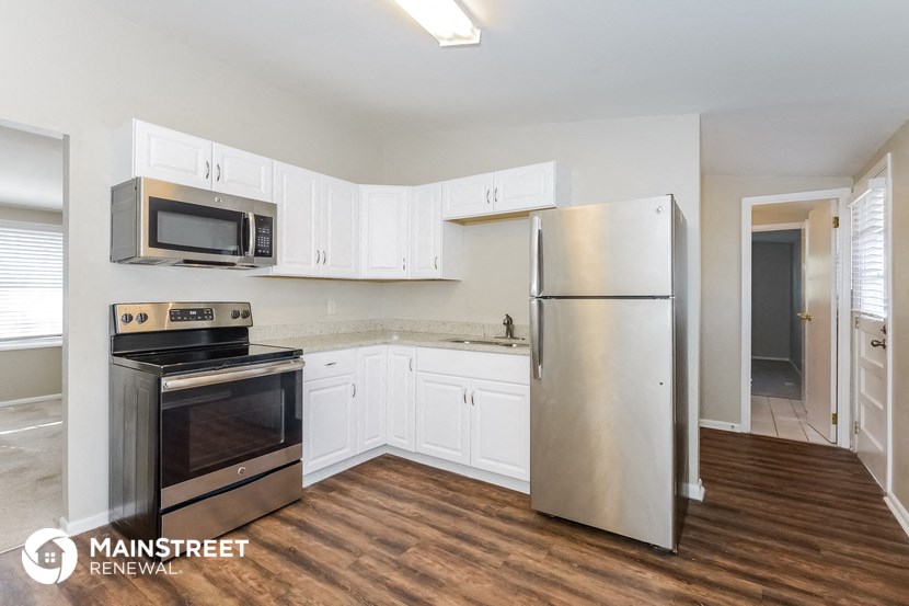 a kitchen with white cabinets and stainless steel appliances