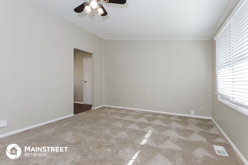 an empty room with a ceiling fan and a window