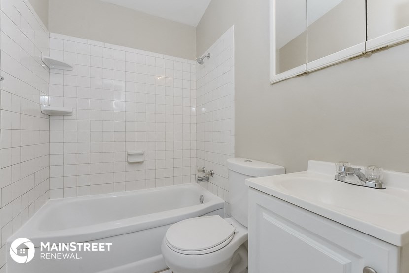a white bathroom with a bath tub and a sink and a toilet