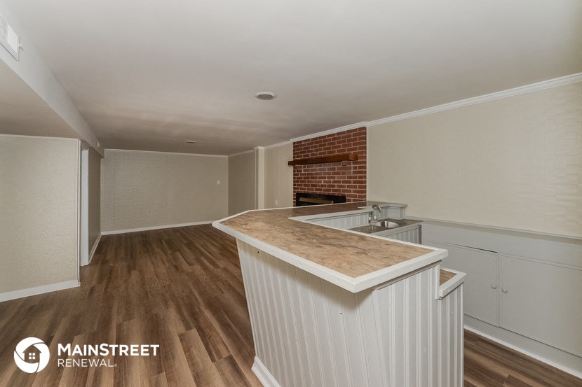 an empty kitchen with a counter top and a fireplace