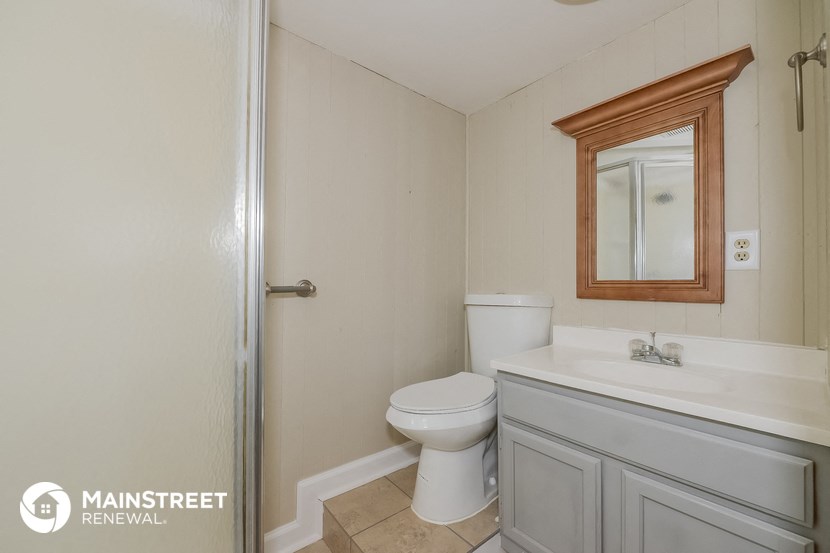 a bathroom with a toilet and a sink and a shower