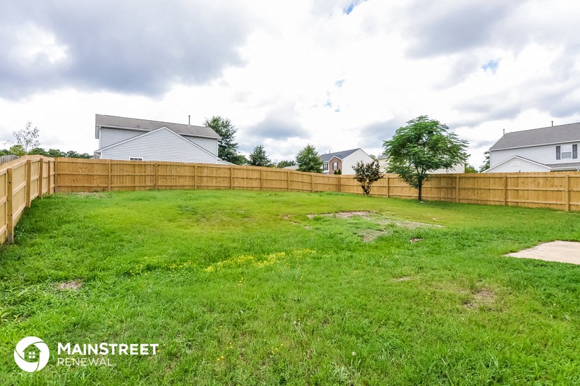 the backyard of a house with a wooden fence