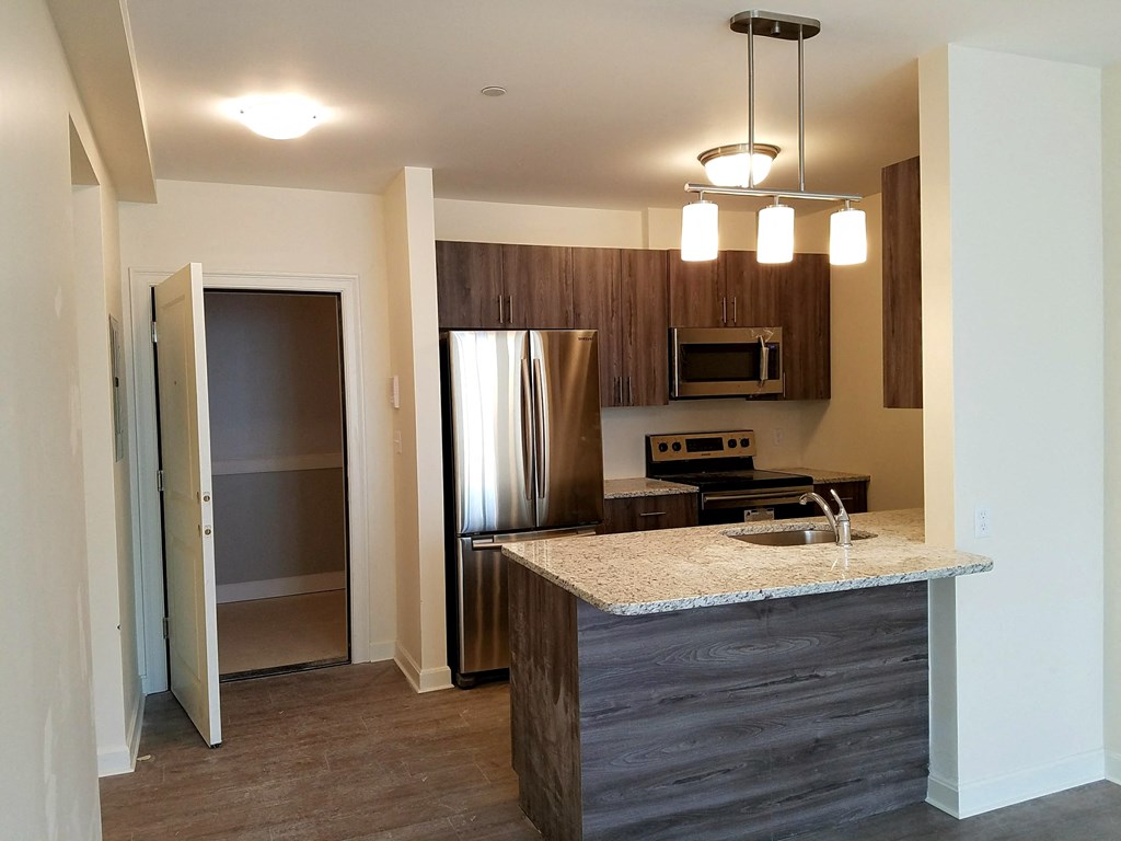 a kitchen with a granite counter top and a stainless steel refrigerator