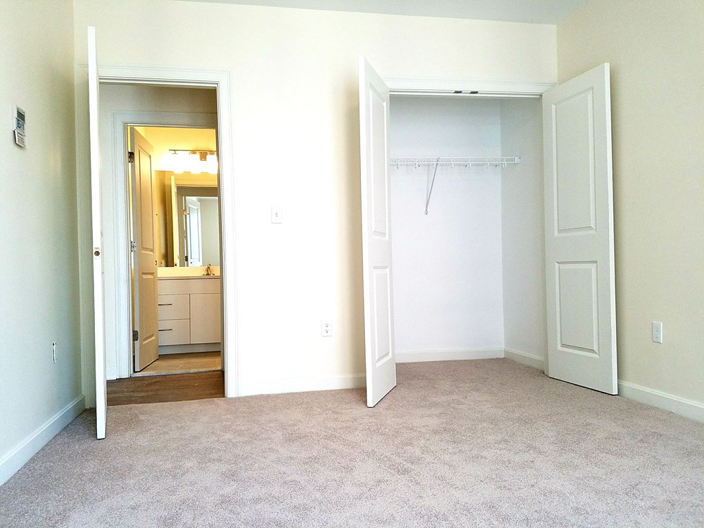 an empty bedroom with a closet and a bathroom
