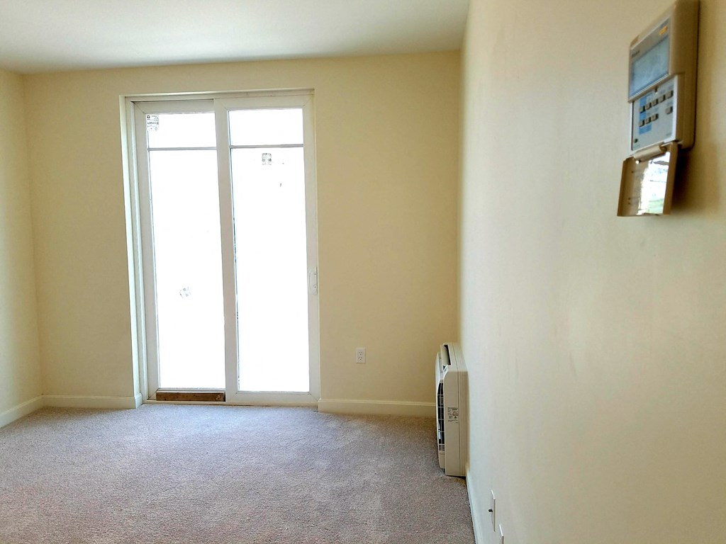 an empty room with a door and a window