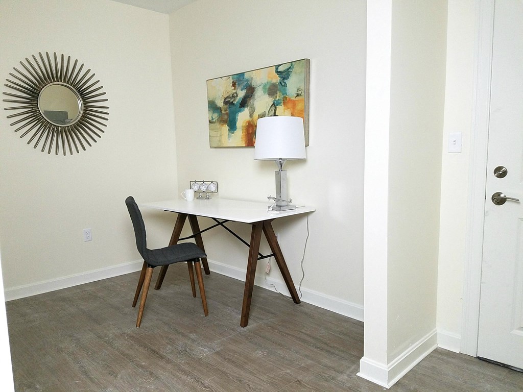 a desk with a lamp and a chair in a room with a mirror