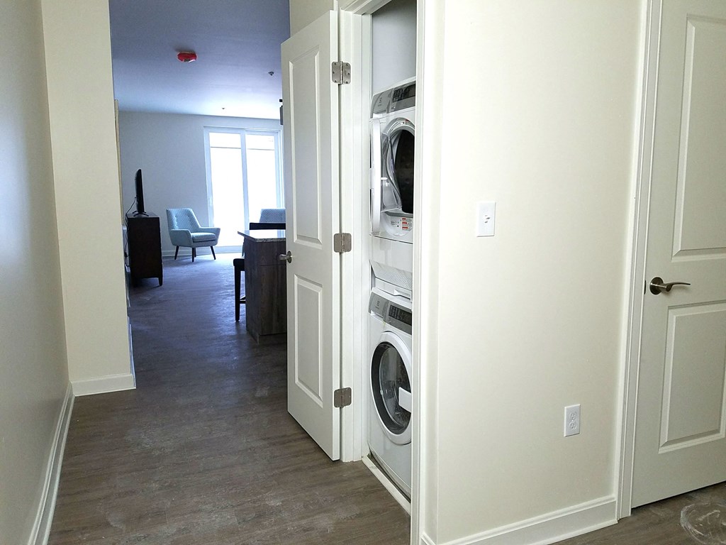 a washer and dryer closet in a hallway with the door open and a