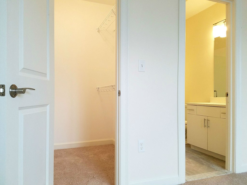 an open door into a bathroom with a sink and a mirror
