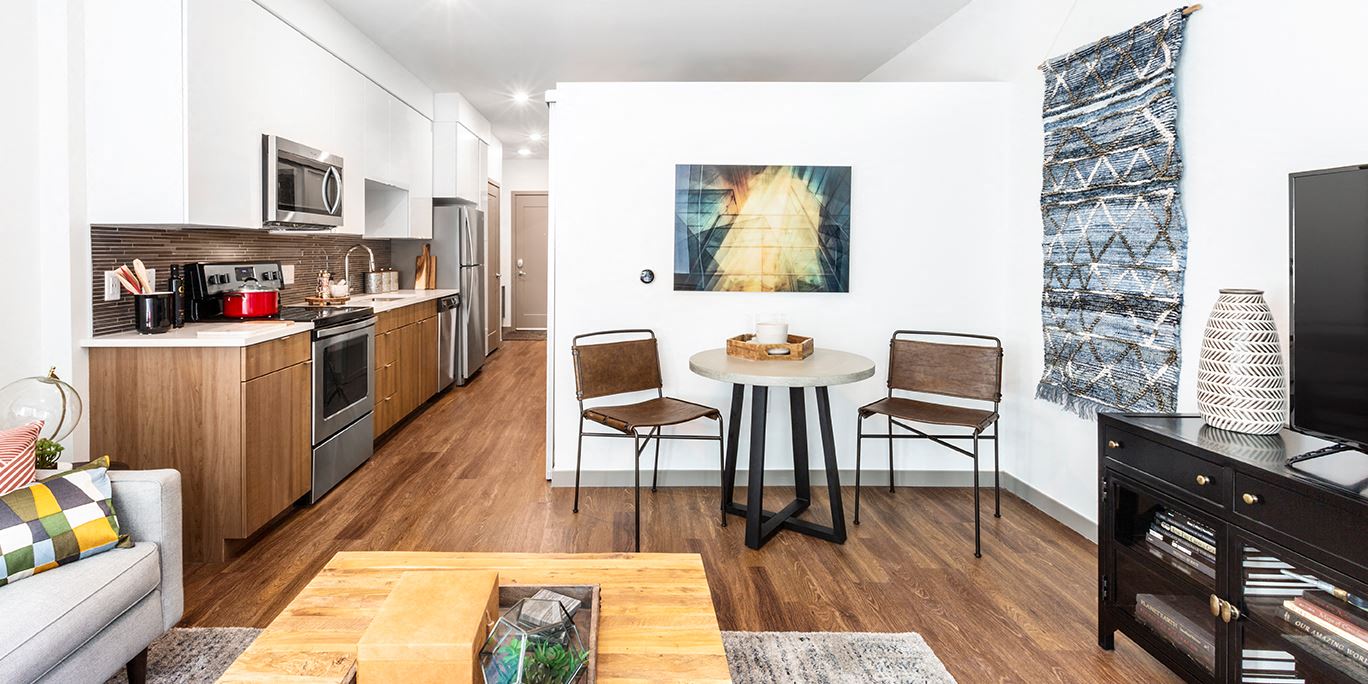 a kitchen and living room with a table and chairs