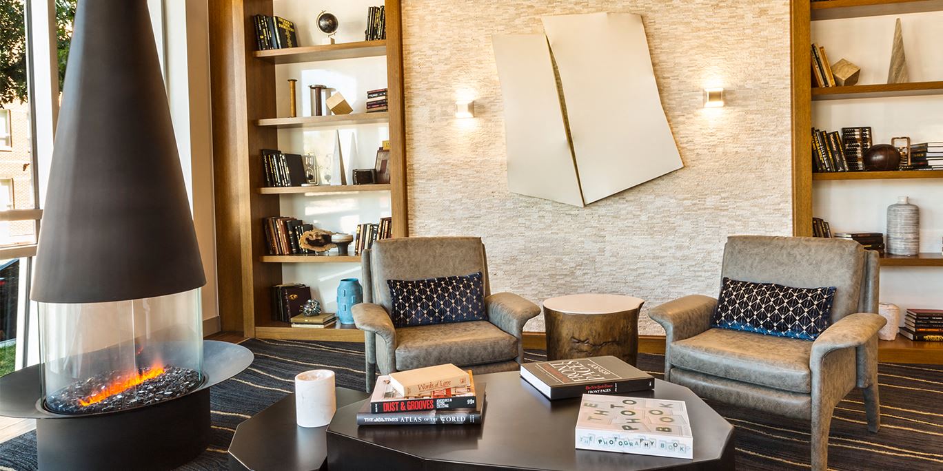 a living room with a fireplace and chairs and a table