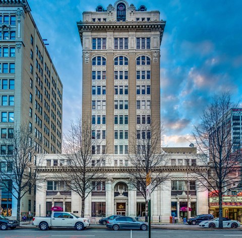 a tall building on a city street with cars