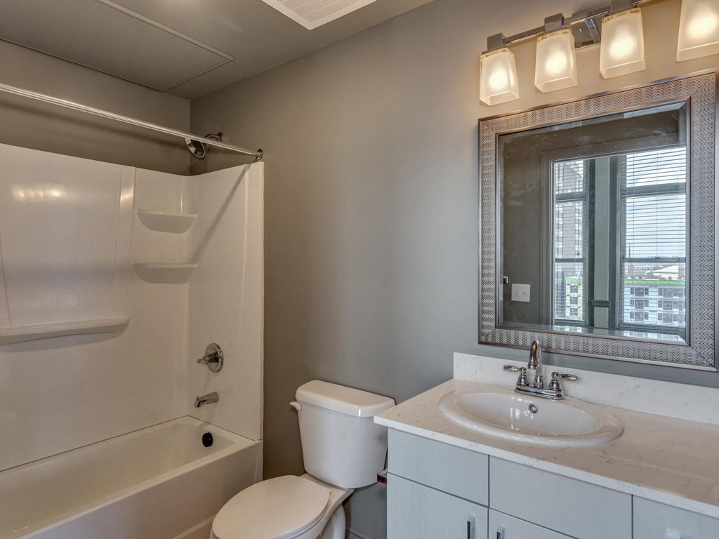 a bathroom with a sink toilet and shower and a mirror