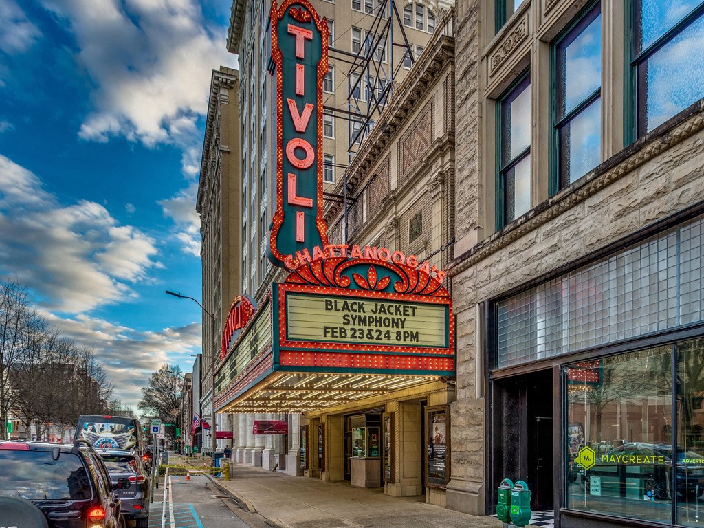 a city street with a large neon sign on the side of a building