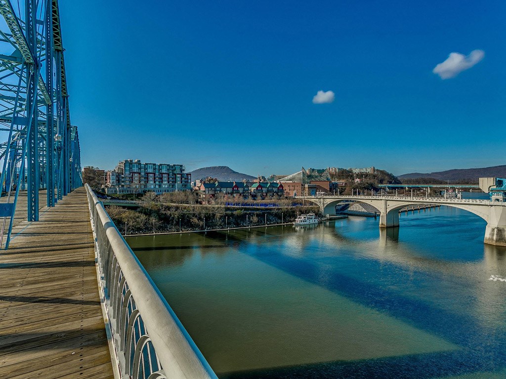 a bridge over a river with a city in the background
