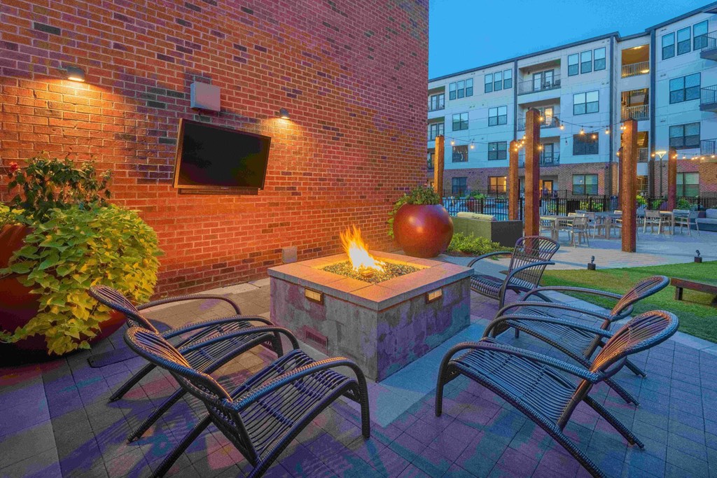 an outdoor patio with a fire pit and chairs