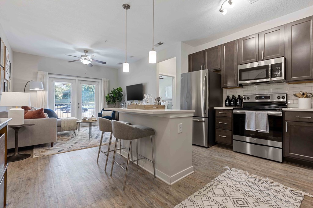 an open kitchen and living room with stainless steel appliances