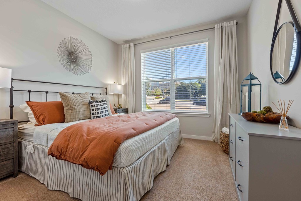 a bedroom with a bed and a large window