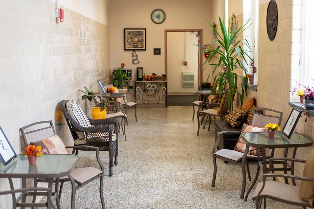 a seating area with tables and chairs in the lobby of a building