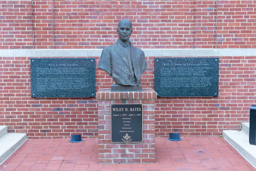 a statue of a man in front of a brick wall