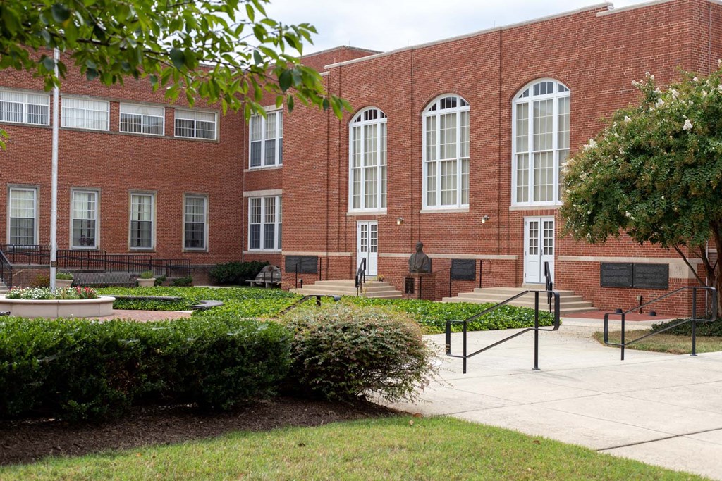 a large brick building with a courtyard in front of it