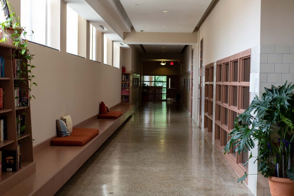 a long hallway with benches and windows in a library