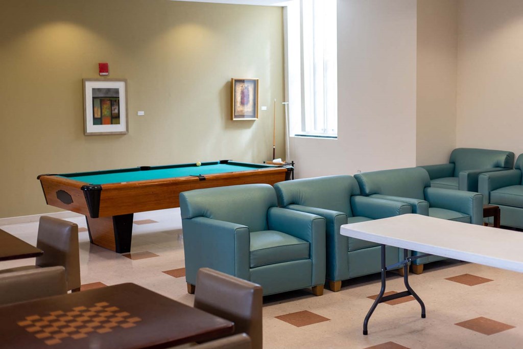 a game room with a pool table and couches