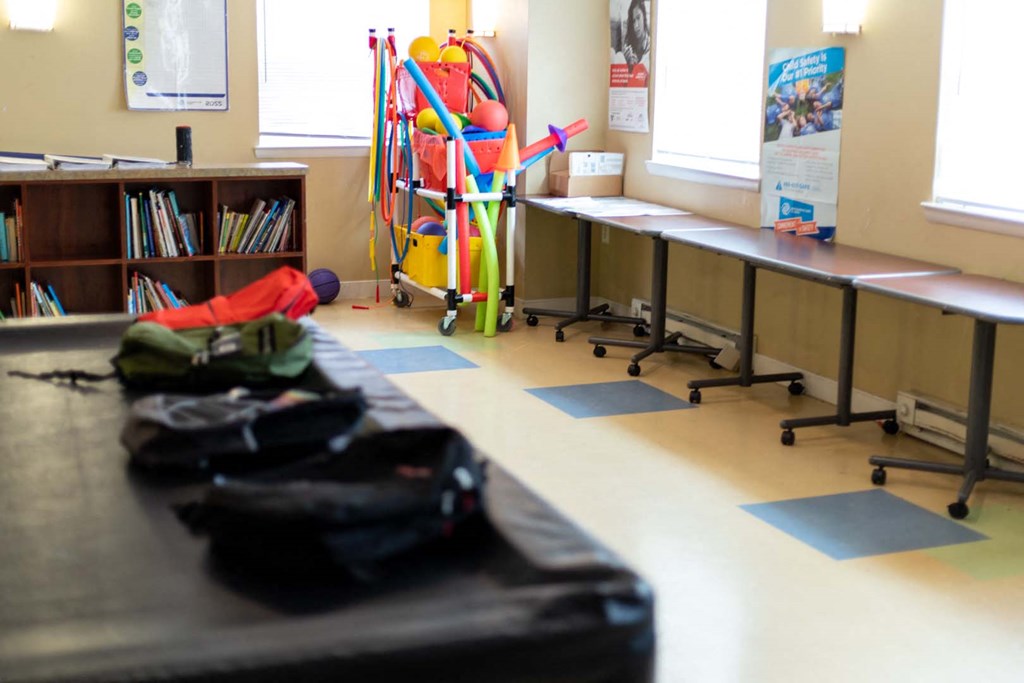 a classroom with desks and chairs and a trolley