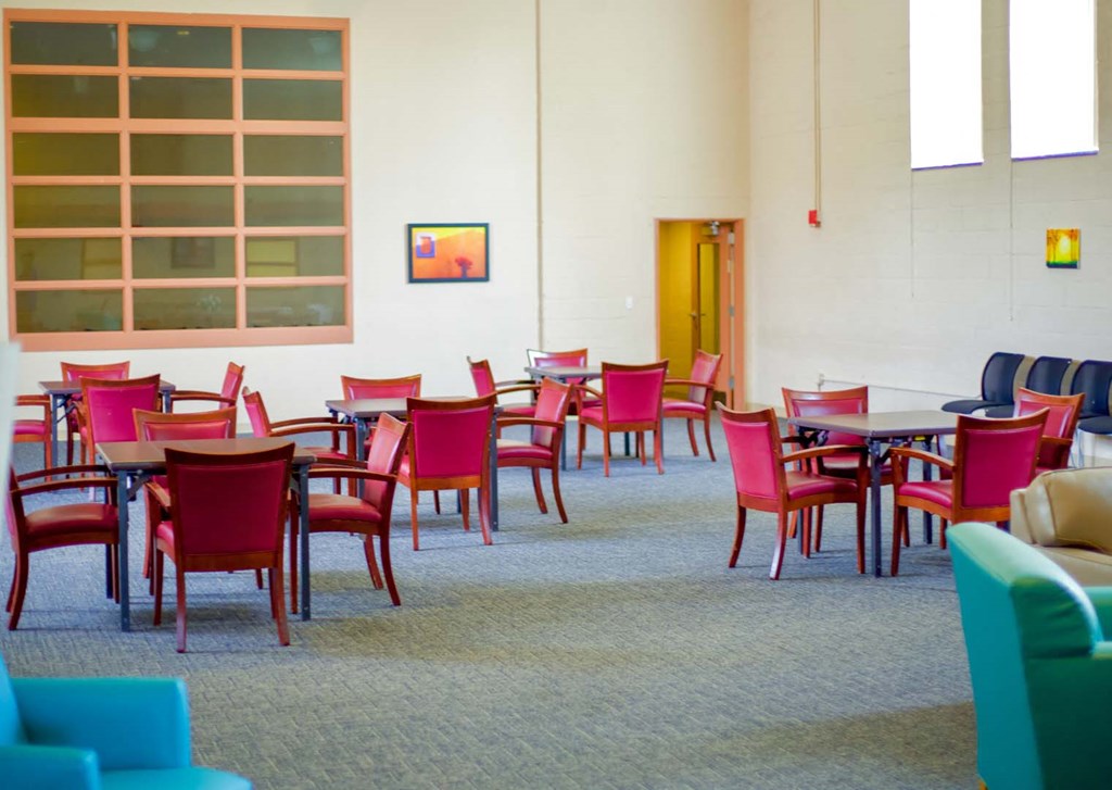 a dining room with red chairs and tables