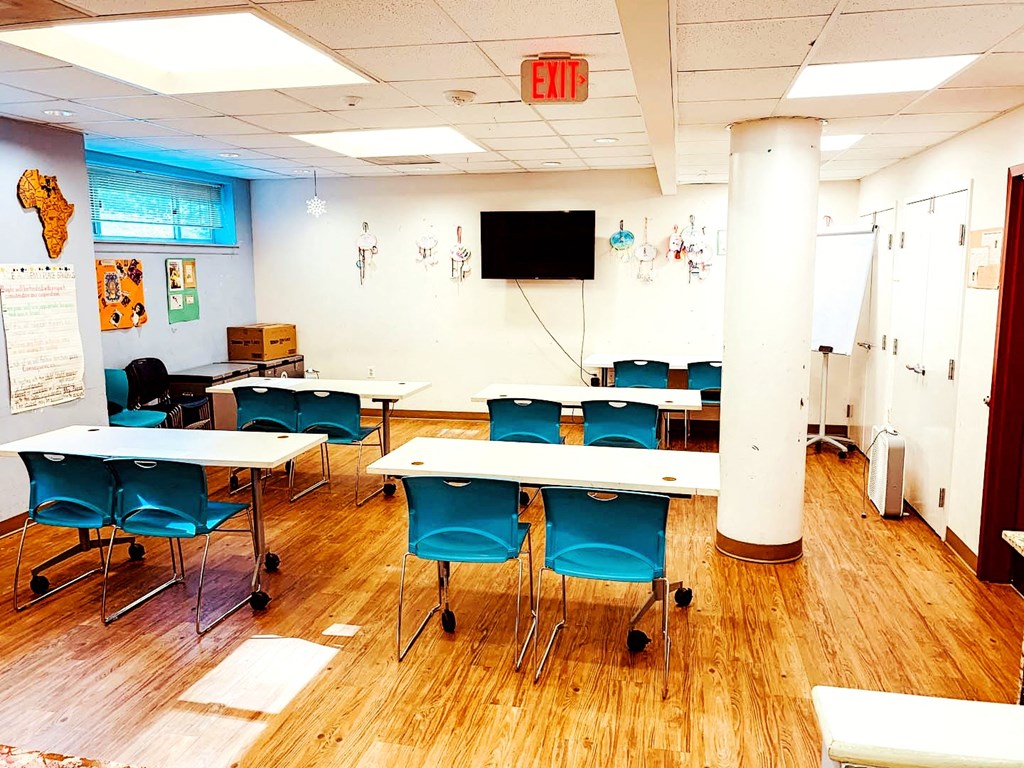 a conference room with tables and chairs and a tv