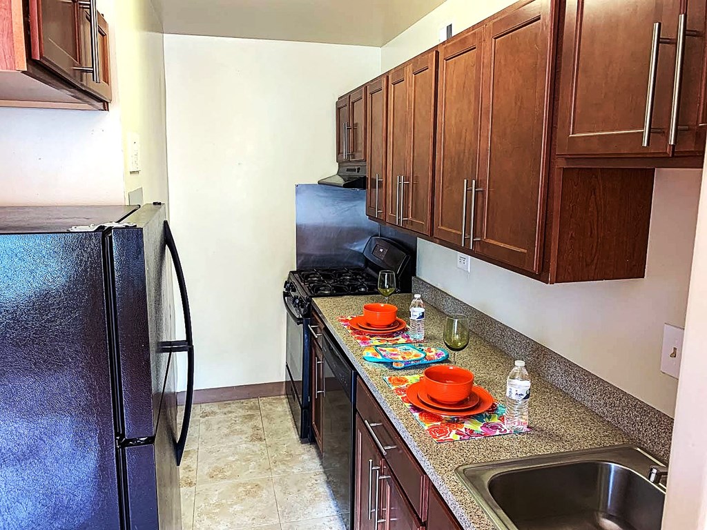 a kitchen with black appliances and a counter top with a sink