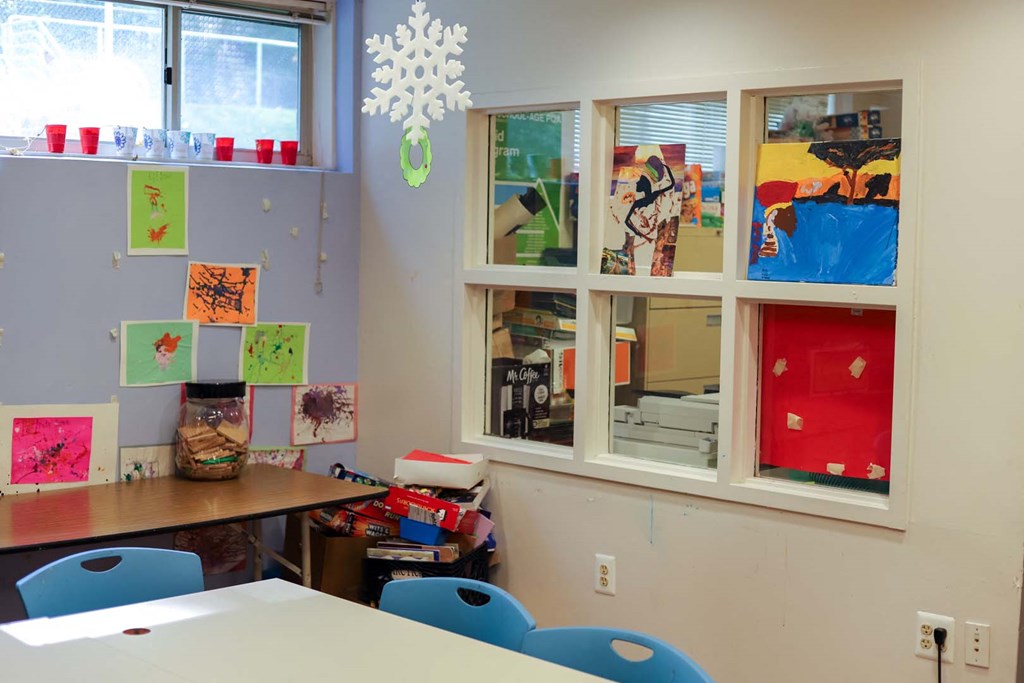 a classroom with a table and chairs and windows