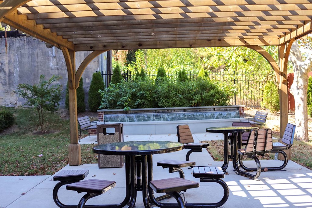 a patio with tables and chairs and a pergola