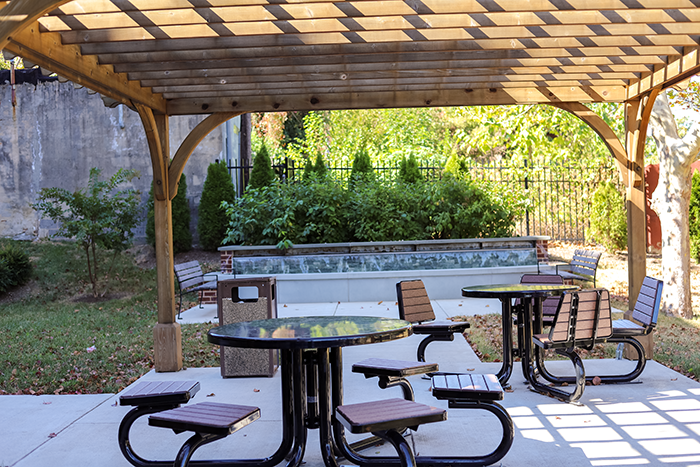a patio with tables and chairs and a pergola