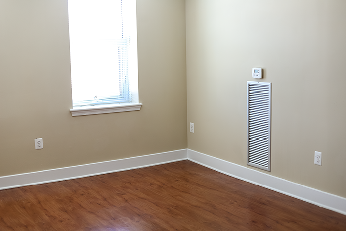an empty room with a radiator and a window