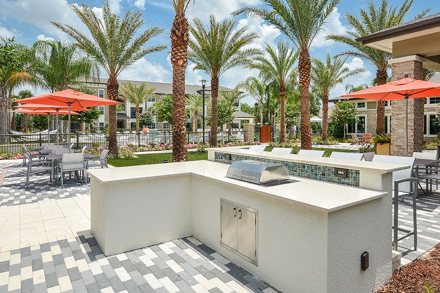 a patio with a bar and tables with umbrellas