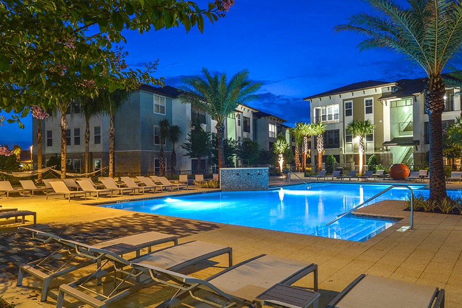 a swimming pool at night at an apartment complex