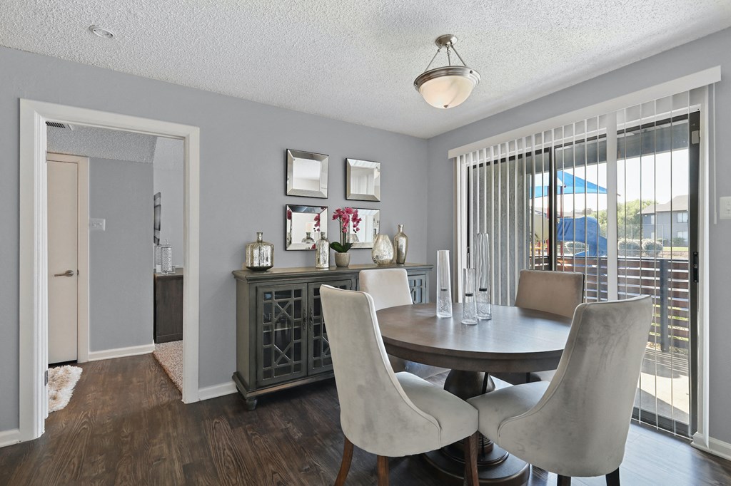 a dining room with a table and chairs and a large window