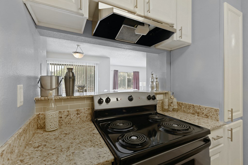 a kitchen with white cabinets and a black stove