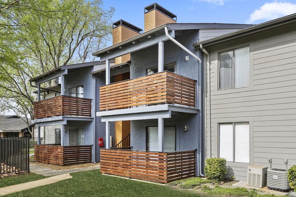 an apartment building with a blue exterior and wooden balconies